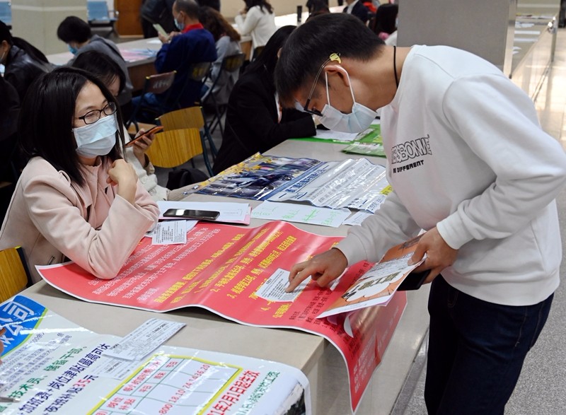 求职者仔细琢磨企业招聘条件（吴觅亮摄）.JPG